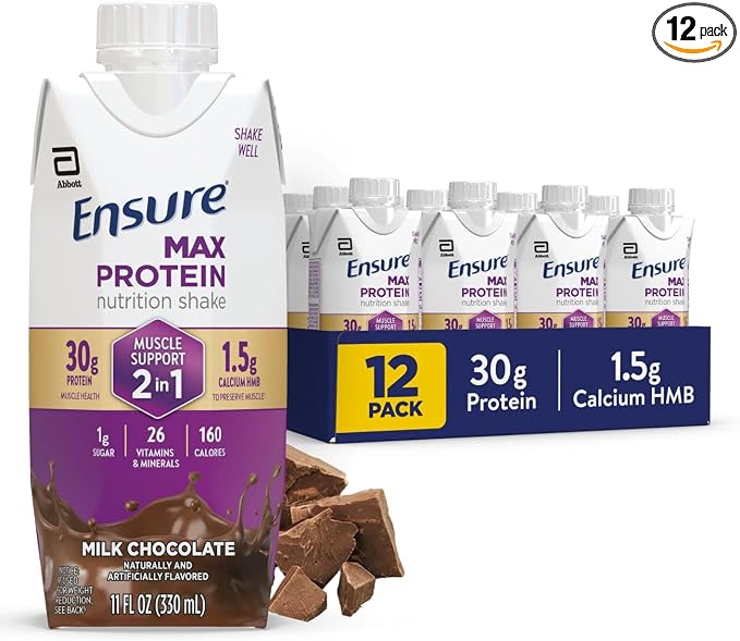 Ensure Max Protein nutrition shake in Milk Chocolate flavor, shown as a single carton in front of a 12-pack display carton. The packaging is white with purple, blue, and gold labeling, and chocolate pieces are placed in front.