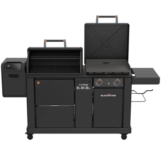 Blackstone dual fuel outdoor grill with a side burner, main grill chamber with lid open, lower storage cabinets, and side table on a white background.