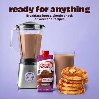 Blender with chocolate smoothie, Premier Protein chocolate powder, glass of smoothie, and stack of waffles on a purple background.