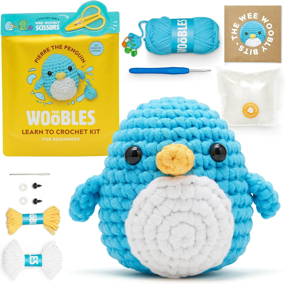 The Woobles Pierre crochet kit with blue penguin example, yarn, hook, accessories and scissors packaging