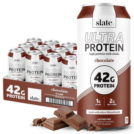 A retail display of 12 cans of slate Ultra Protein chocolate milk shake next to a single large can, with chocolate chunks in front, on a white background.